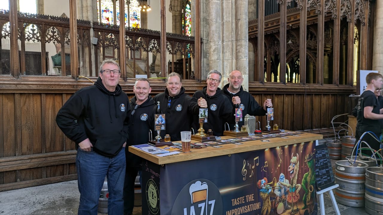 The five Jazz BrewCo founders behind their festival bar with the Taste the Improvisation banner and beer pump clips
